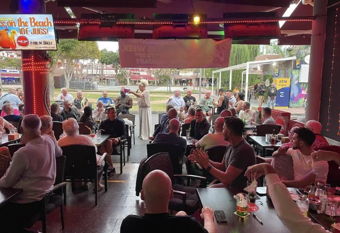 Mardi Gras gay bar in Gran Canaria. Drag queen performing at a gay bar, entertaining a crowd of gay men. Gay travel advice.