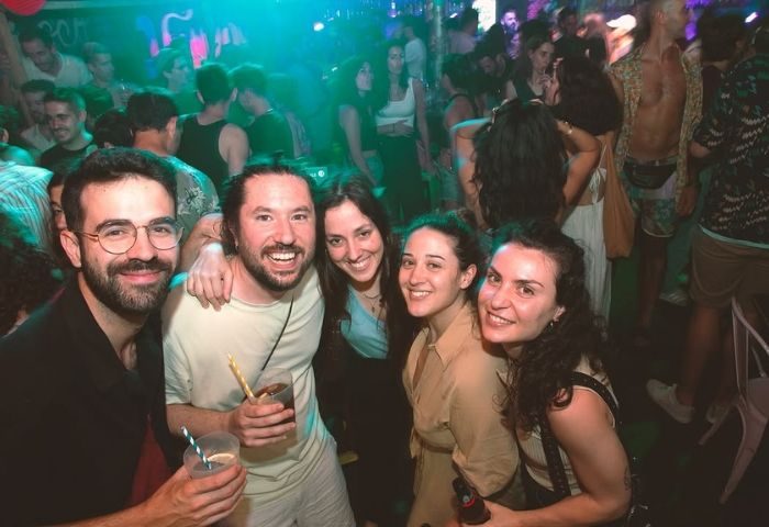 People enjoying Maricon Ghetto Friendly Bar, a popular gay bar in Barcelona. Nightlife scene, friends, drinks, and vibrant atmosphere.