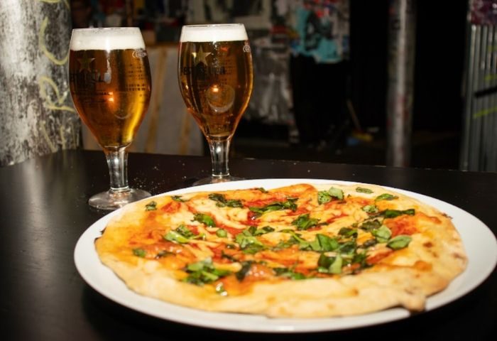 Pizza and beers at Maricon, a gay-friendly bar in Barcelona. Enjoy the ghetto-friendly atmosphere and delicious food!
