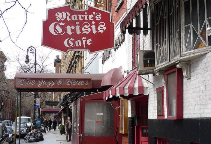 Marie's Crisis Cafe, a gay sing-a-long bar in New York City. Features a red awning and signage for live jazz and blues. Gay travel destination.