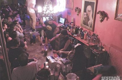 Marrakech Salon Gay Bar in Mexico: Lively scene in a gay bar. People drinking, bartender mixing drinks, and a person standing on the bar.