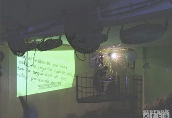 Marrakech Salon Gay Bar in Mexico: DJ on a platform under disco balls. Green wall projection. Gay travel nightlife scene.