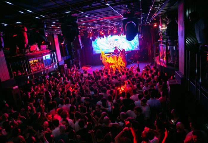 Marta Cariño Gay Club in Madrid: A packed dance floor, DJ on stage, vibrant lighting. A popular gay nightlife destination.