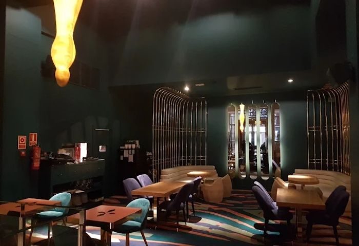 Interior of Marta Cariño, a gay club in Madrid. The bar features stylish seating, tables, and decor with a modern, upscale vibe.