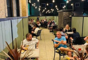 Marty's Martini Bar in Chicago: Gay party with drinks. People are enjoying the outdoor patio with string lights at this gay bar.