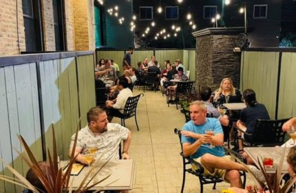 Marty's Martini Bar in Chicago: Gay party with drinks. People are enjoying the outdoor patio with string lights at this gay bar.