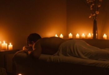 Gay massage in Barcelona. Relaxed man lies on a massage table surrounded by candles. Travel advice for gay men.