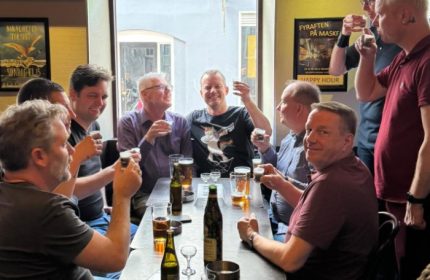 Gay men at Masken Bar in Copenhagen. Group of friends drinking beer and shots in a pub. Gay travel advice.