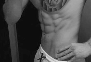 Massage By Bret: Torso of muscular man with abs and tattoo. Gay massage spa promotional image. Black and white.