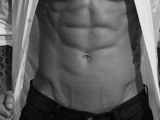 Massage By Bret: Torso of a muscular man with abs, open shirt, and tattoos. Gay massage spa concept.