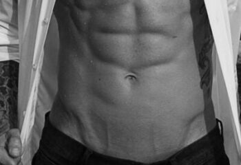 Massage By Bret: Torso of a muscular man with abs, open shirt, and tattoos. Gay massage spa concept.