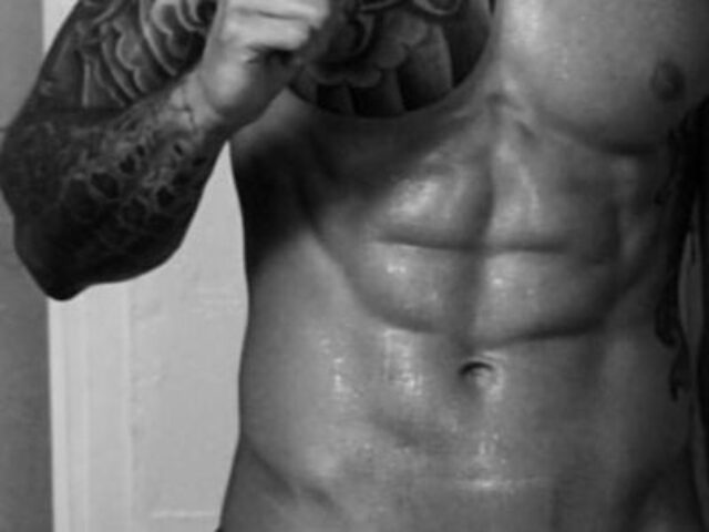 Muscular torso with abs, tattoo on arm. Massage By Bret, gay massage spa. Black and white image for gay men travel advice.