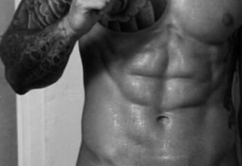 Muscular torso with abs, tattoo on arm. Massage By Bret, gay massage spa. Black and white image for gay men travel advice.