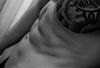 Black and white close-up of a torso with a tattoo. Massage By Bret, a gay massage spa, offers relaxation and bodywork for gay men.