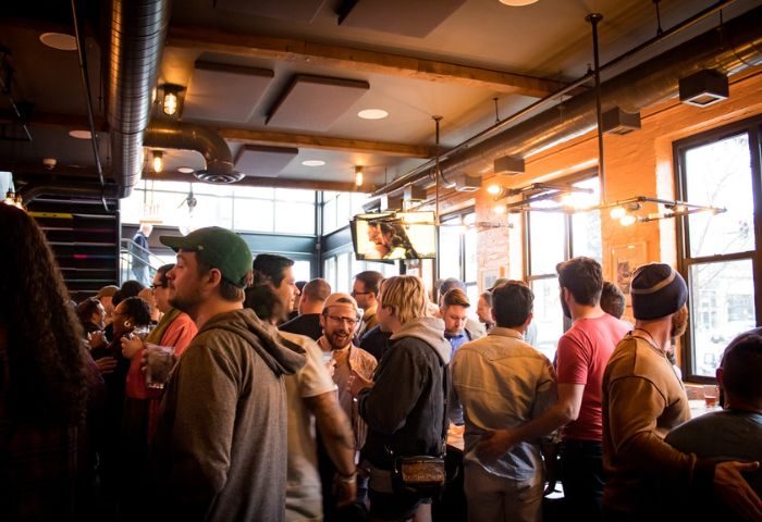 Meeting House Tavern, a unique gay bar in Chicago. Interior view of a crowded bar with men socializing. Gay travel advice.