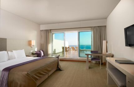 Meliá Madeira Mare Hotel room. Gay travel advice. Balcony view of the ocean, bed, desk, and tv. Meliá Madeira Mare Hotel interior.