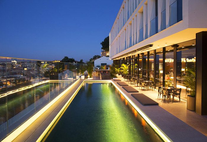 Memmo Principe Real Design Hotel rooftop pool at night in Lisbon's gayborhood. Luxury hotel with city views. Perfect for gay travel.