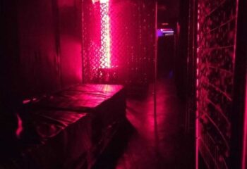 Dark interior of Men Factory Gay Cruise Club in Barcelona, Spain. Red lighting, beds, and maze-like corridors for gay men's travel.