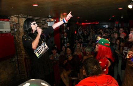 Drag queen performs at Metropolitan Bar, a queer bar in New York. Crowd enjoys the show. Gay travel advice.