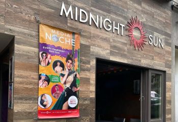 Midnight Sun Video Bar in San Francisco. Signage and a banner advertising Media Noche with drag queens and Latinx gogos. Gay travel advice.