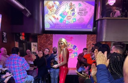 Drag queen performs at Midnight Sun Video Bar in San Francisco during a Fresas Brunch event. Patrons watch and applaud the performance. Gay travel.