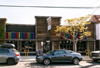Mineshaft Gay Bar exterior. Wood building with rainbow flags. A popular gay bar, a must-see on your gay travel adventure.