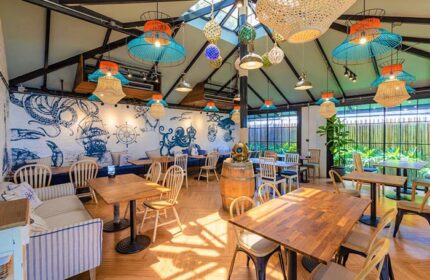 Holiday Inn Express Krabi Ao Nang Beach's modern design. Gay Krabi beach hotel interior with nautical decor, tables, and chairs.