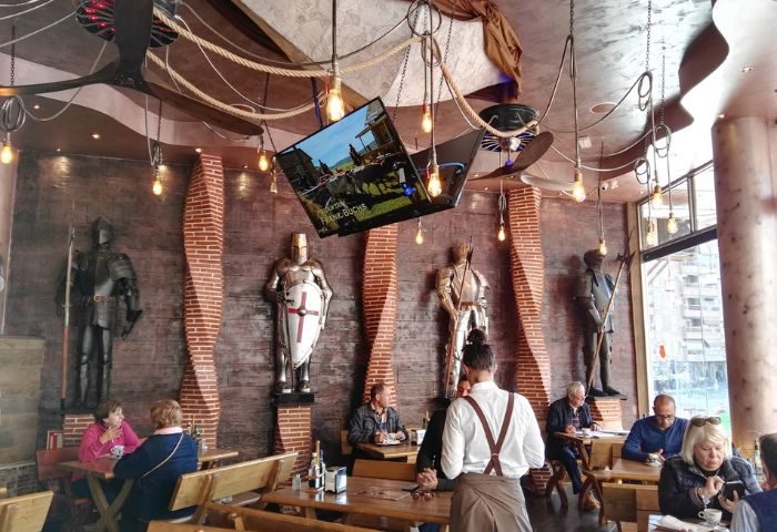 Molino Benidorm interior: Gay-friendly restaurant with live shows. Medieval decor, suits of armor, and TV. Popular gay travel destination.