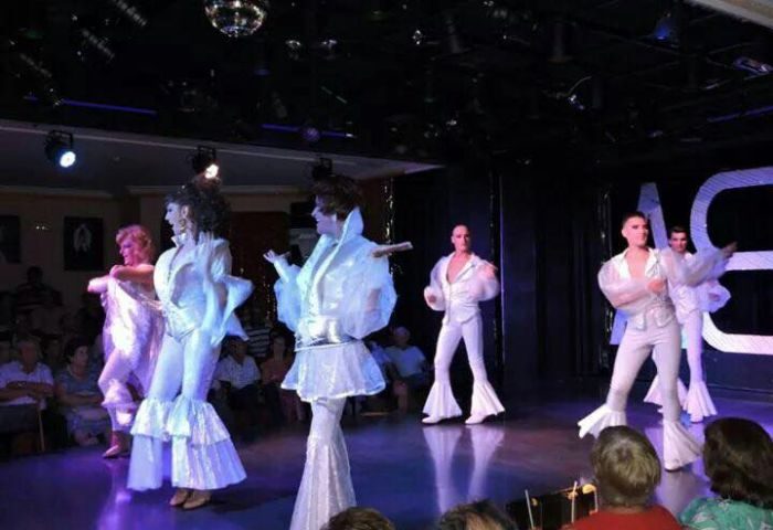 Molino Benidorm gay live shows. Performers in white costumes on stage. Gay nightlife in Benidorm, Spain. Entertainment for gay men.