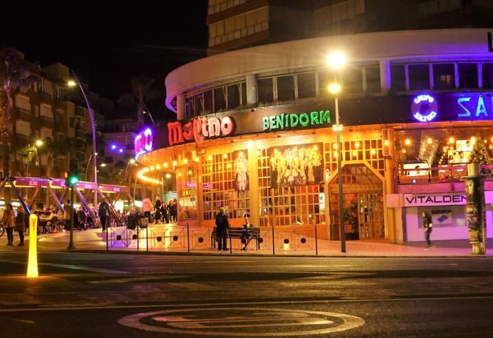 Molino Benidorm at night. A popular gay venue with live shows in Benidorm, Spain. Illuminated facade with people outside. Gay travel.