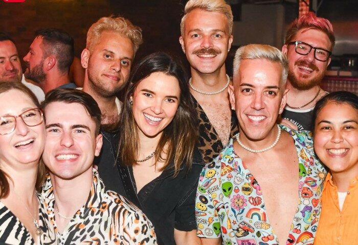 Group of smiling people at Mollie's Bar and Diner, Melbourne. Gay travel advice, gay bar, diner, Melbourne. Fun night out, diverse group.