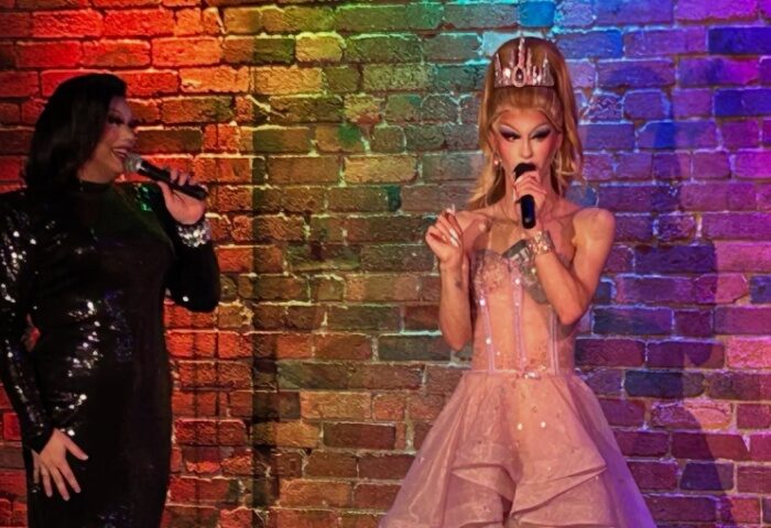 Drag queens perform at Mollie's Bar and Diner, Melbourne. Gay travel destination with rainbow brick wall backdrop. Nightlife entertainment.