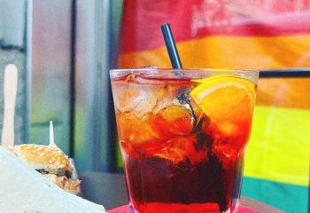Milan gay bar drink. Aperol spritz with orange slice and straw. Refreshing cocktail at Mono Bar, Milan. Gay travel advice.