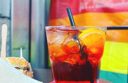 Milan gay bar drink. Aperol spritz with orange slice and straw. Refreshing cocktail at Mono Bar, Milan. Gay travel advice.