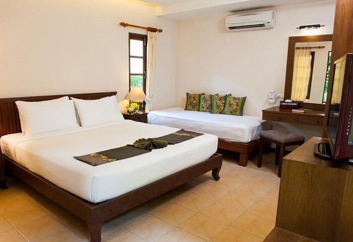 Montien House Hotel room, Koh Samui. Cheap beachfront gay hotel with pool. Queen bed, daybed, TV, & desk. Gay travel advice.