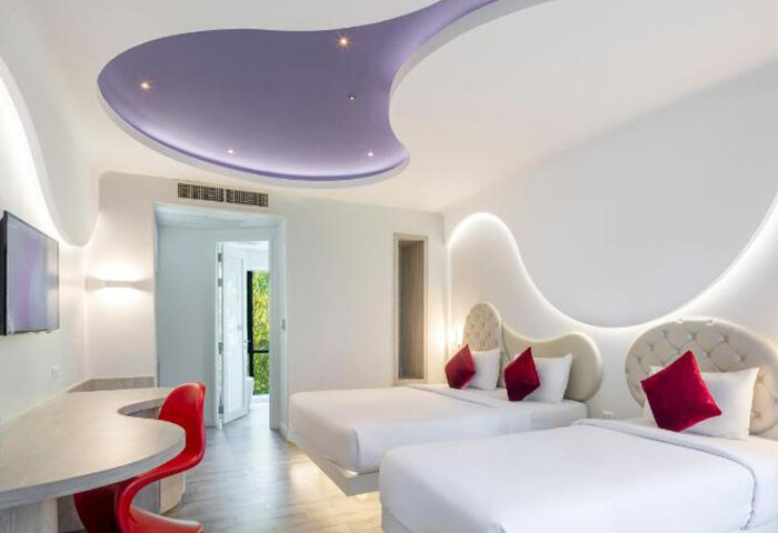 Avatara Resort Koh Samet room. Gay-friendly beachfront hotel with two beds, red accents, and modern design. Ideal for friends' getaway.