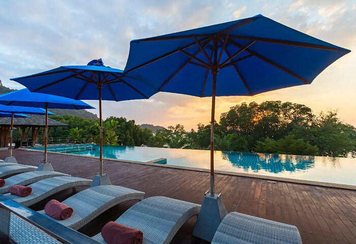 Railay Princess Resort & Spa rooftop pool view at sunset. Beachfront hotel in Krabi, Thailand. Gay travel destination with sun loungers.