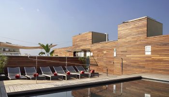 Hotel Soho rooftop pool in Barcelona's gayborhood. Budget-friendly gay hotel with sun loungers, wood accents, and a relaxing vibe.