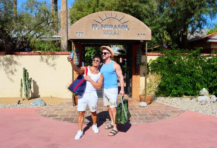 Gay couple takes a selfie at El Mirasol Villas, a budget-friendly, men-only resort in Palm Springs. Vacation vibes at this popular destination.