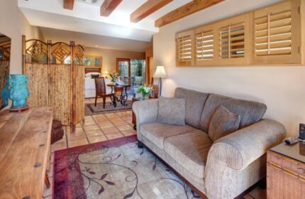The Hacienda at Warm Sands suite. Budget luxury gay resort in Palm Springs with living room, sofa, and view to bedroom and patio.