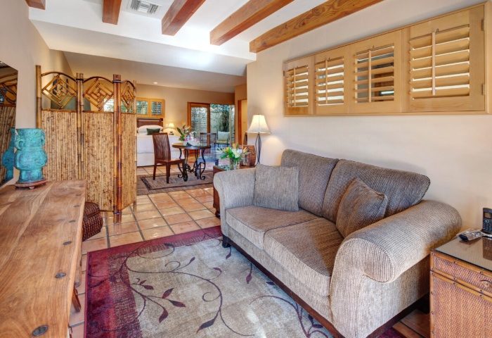 The Hacienda at Warm Sands suite. Budget luxury gay resort in Palm Springs with living room, sofa, and view to bedroom and patio.