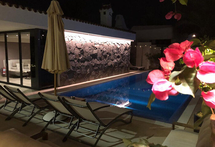 Villa Adler Gay Men Only pool at night. Gran Canaria gay hotel near Yumbo gay nightlife in Playa del Ingles, with lounge chairs.