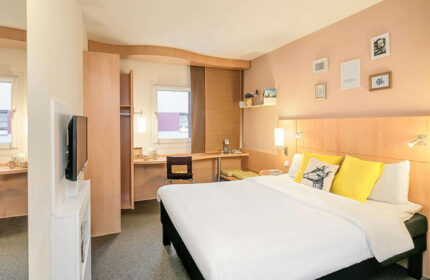 Ibis Praha Old Town Hotel room. City center Prague gay hotel with a bed, desk, TV, & closet. Great for gay travelers in Prague.
