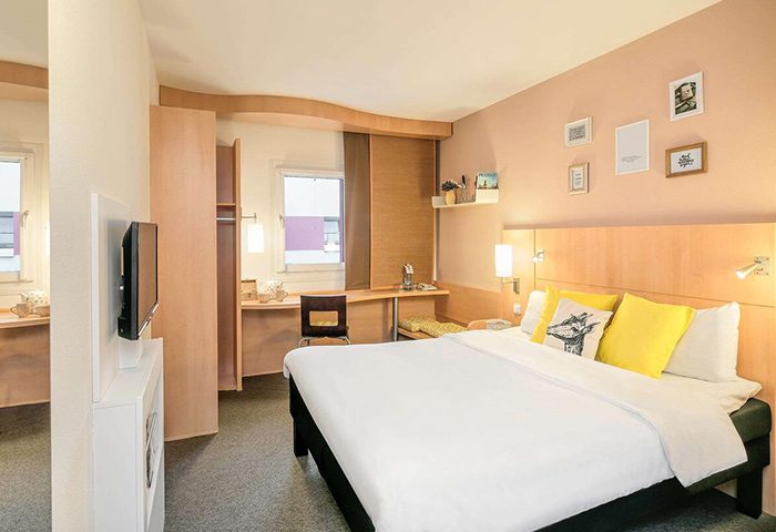 Ibis Praha Old Town Hotel room. City center Prague gay hotel with a bed, desk, TV, & closet. Great for gay travelers in Prague.