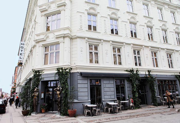 Axel Guldsmeden Hotel, Copenhagen. Most-booked gay-friendly hotel in the city center's gayborhood. Exterior view with tables and statues.