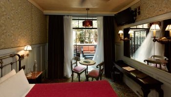 The Jane Hotel, New York: Interior view of a room. The most-booked gay-friendly hotel features a bed, table, and a terrace with seating.