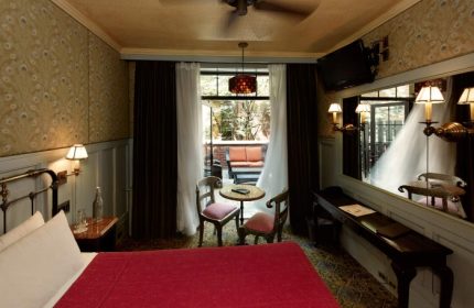 The Jane Hotel, New York: Interior view of a room. The most-booked gay-friendly hotel features a bed, table, and a terrace with seating.