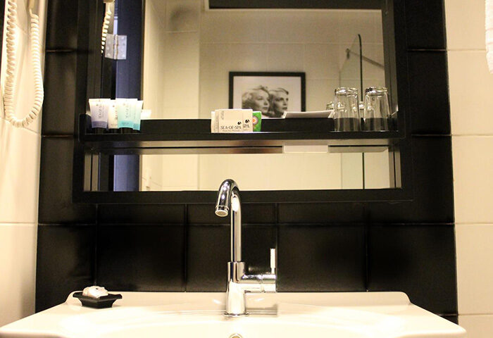 Cinema Hotel Tel Aviv bathroom. Modern sink, mirror, and amenities. Gay honeymoon hotel in Tel Aviv City Center. Atlas Boutique Hotel.