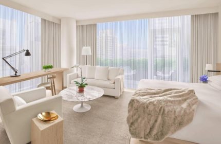 Times Square EDITION hotel suite. Gay honeymoon in Hells Kitchen. Modern design, white furniture, city view. Luxury travel for gay men.