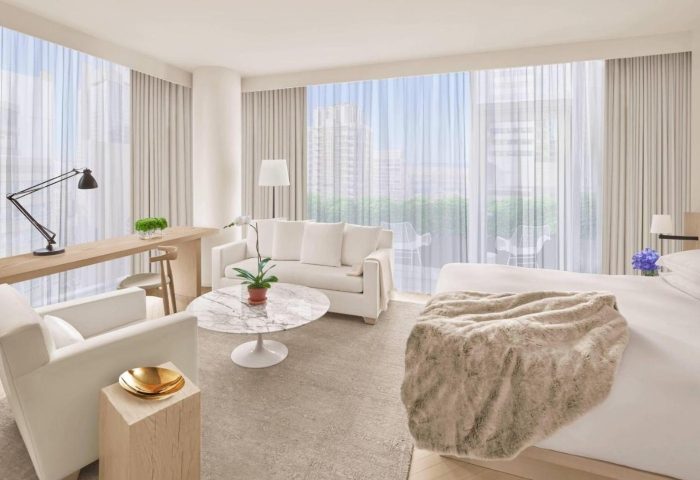 Times Square EDITION hotel suite. Gay honeymoon in Hells Kitchen. Modern design, white furniture, city view. Luxury travel for gay men.